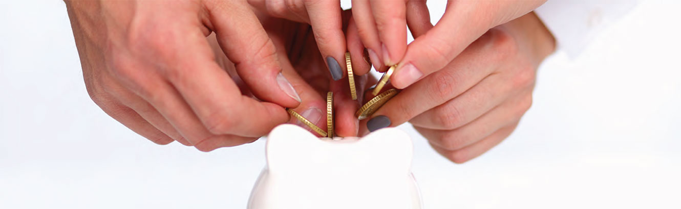 Family putting coins in a piggy bank.